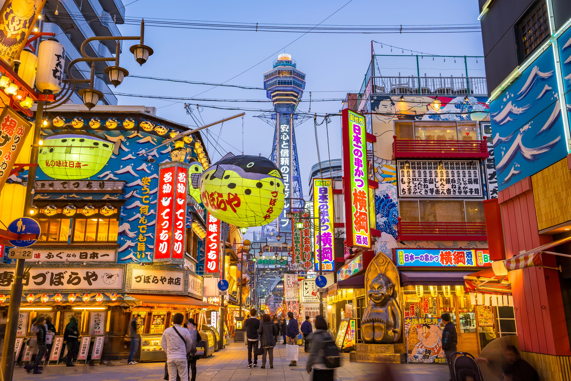 Vibrant Osaka street scene with neon signs and Tsutenkaku Tower